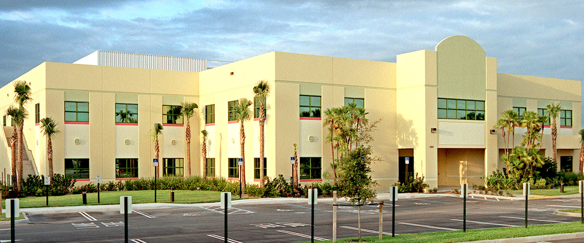 Modern educational facility with palm trees and landscaped grounds, designed for safety and innovation, reflecting Leighton McGinn's commitment to inspiring learning environments.